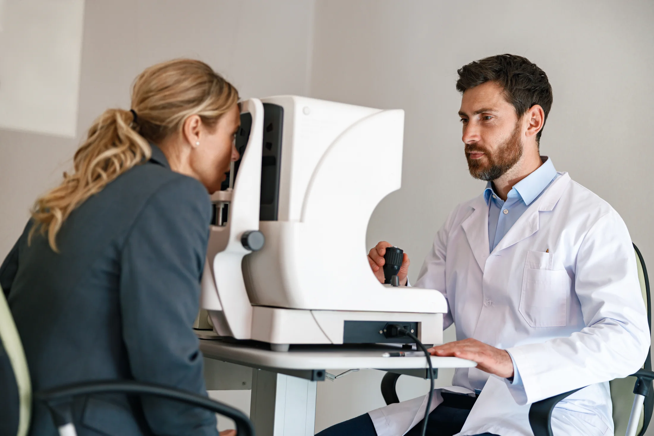 Eye doctor performing eye exam with professional eye examination equipment