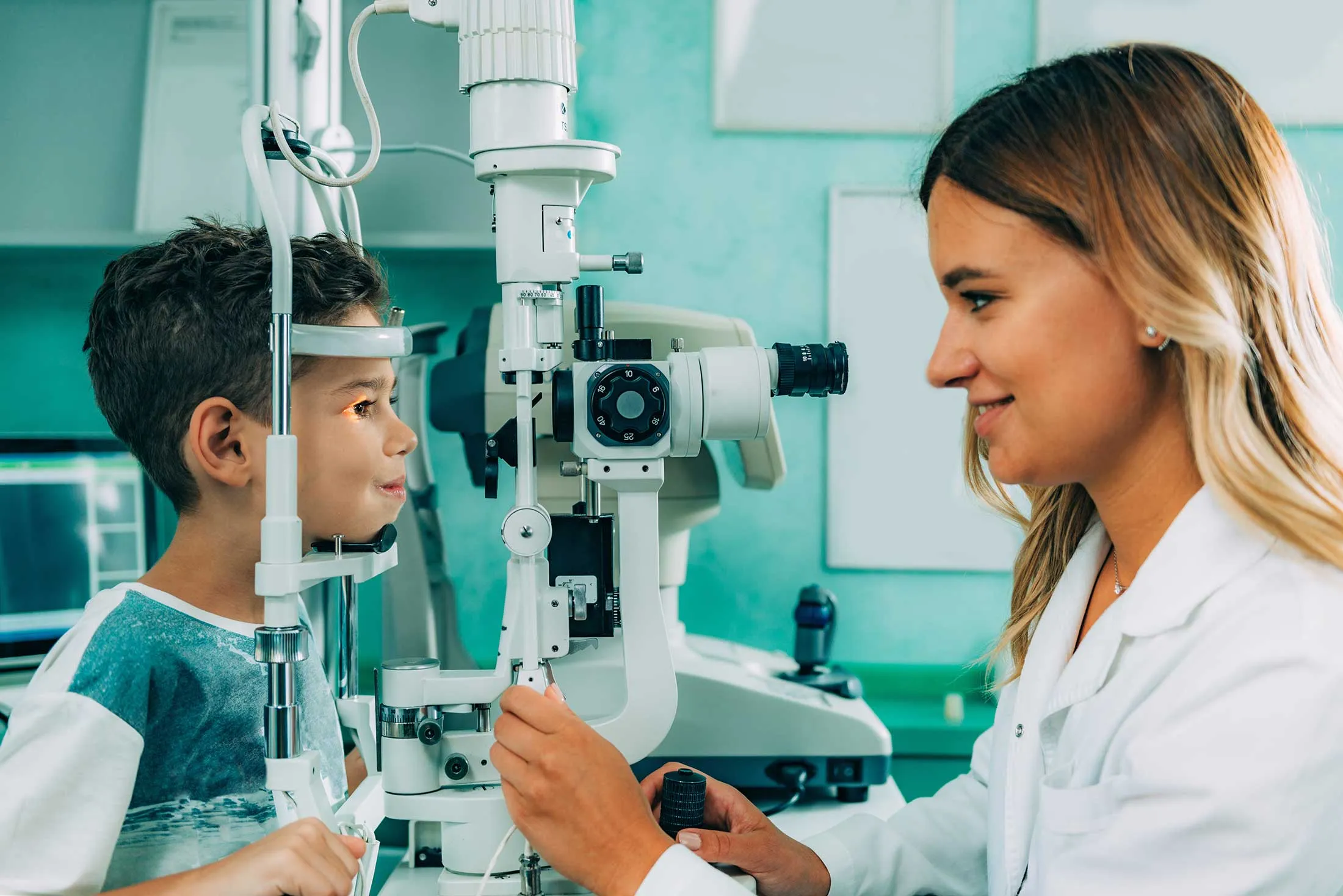 Eye doctor examining child's vision using professional ophthalmology equipment