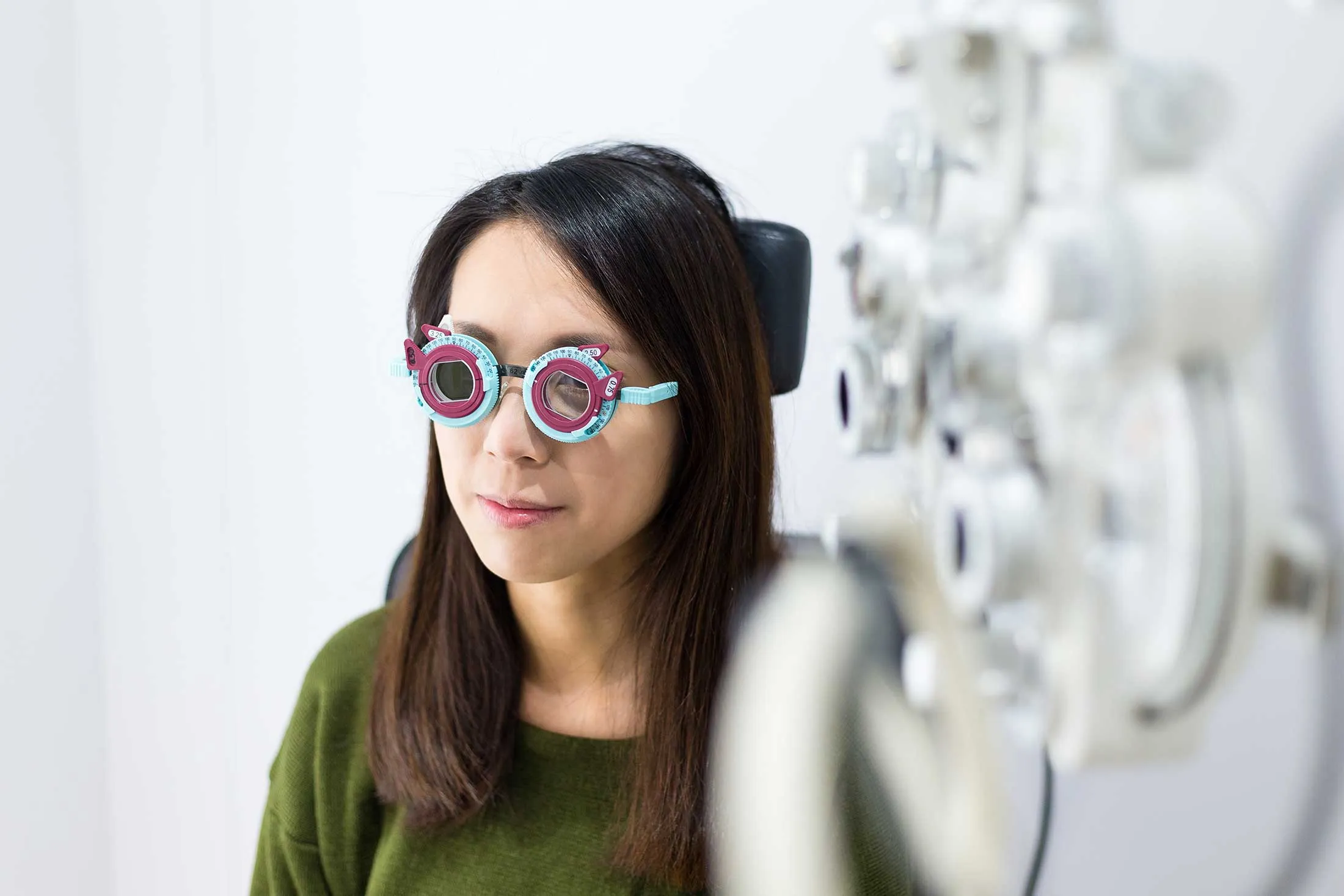 Eye exam with colorful diagnostic glasses in optometrist's office