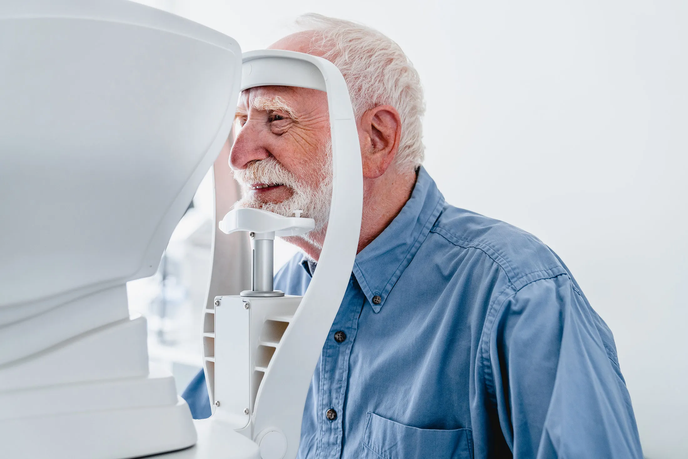 Older person undergoing eye exam with medical diagnostic equipment