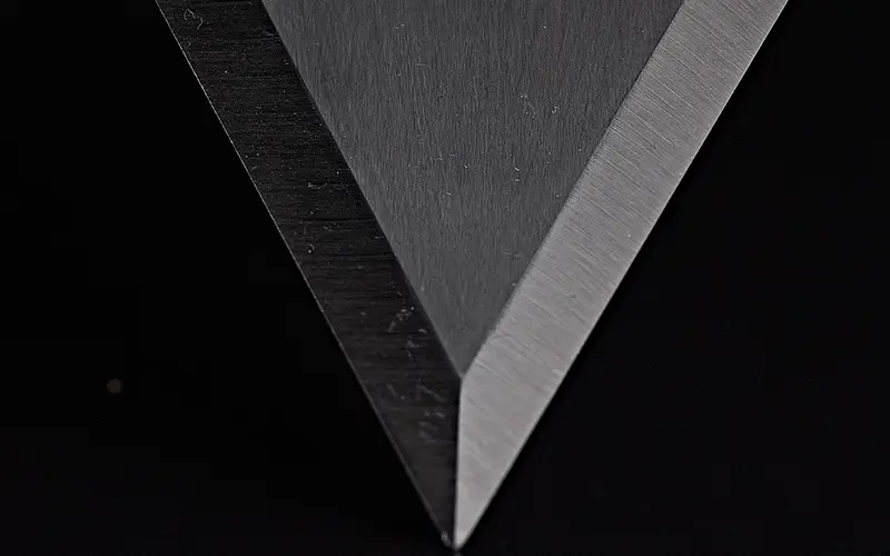 Close-up of a sharp V-shape onion peeler blade, manufactured by Durham Duplex for precision food processing application.