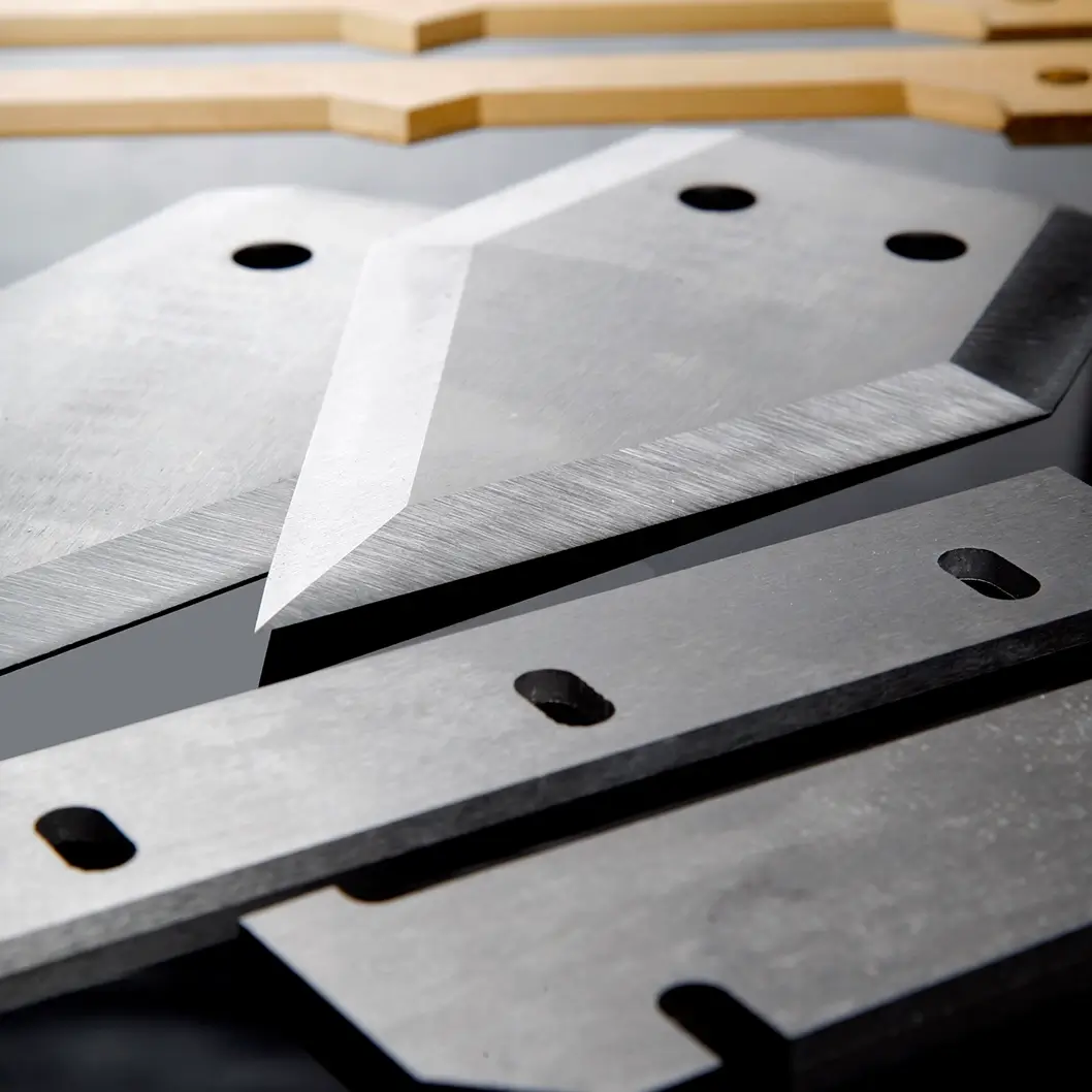 A close-up of angled industrial blades with mounting holes, manufactured by Durham Duplex for heavy duty cutting applications.