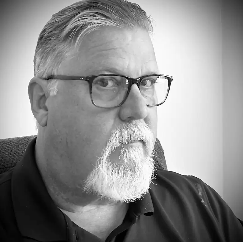 A male called Dave who is the sales director, is in a black and white image looking into the camera to show he is part of the team.