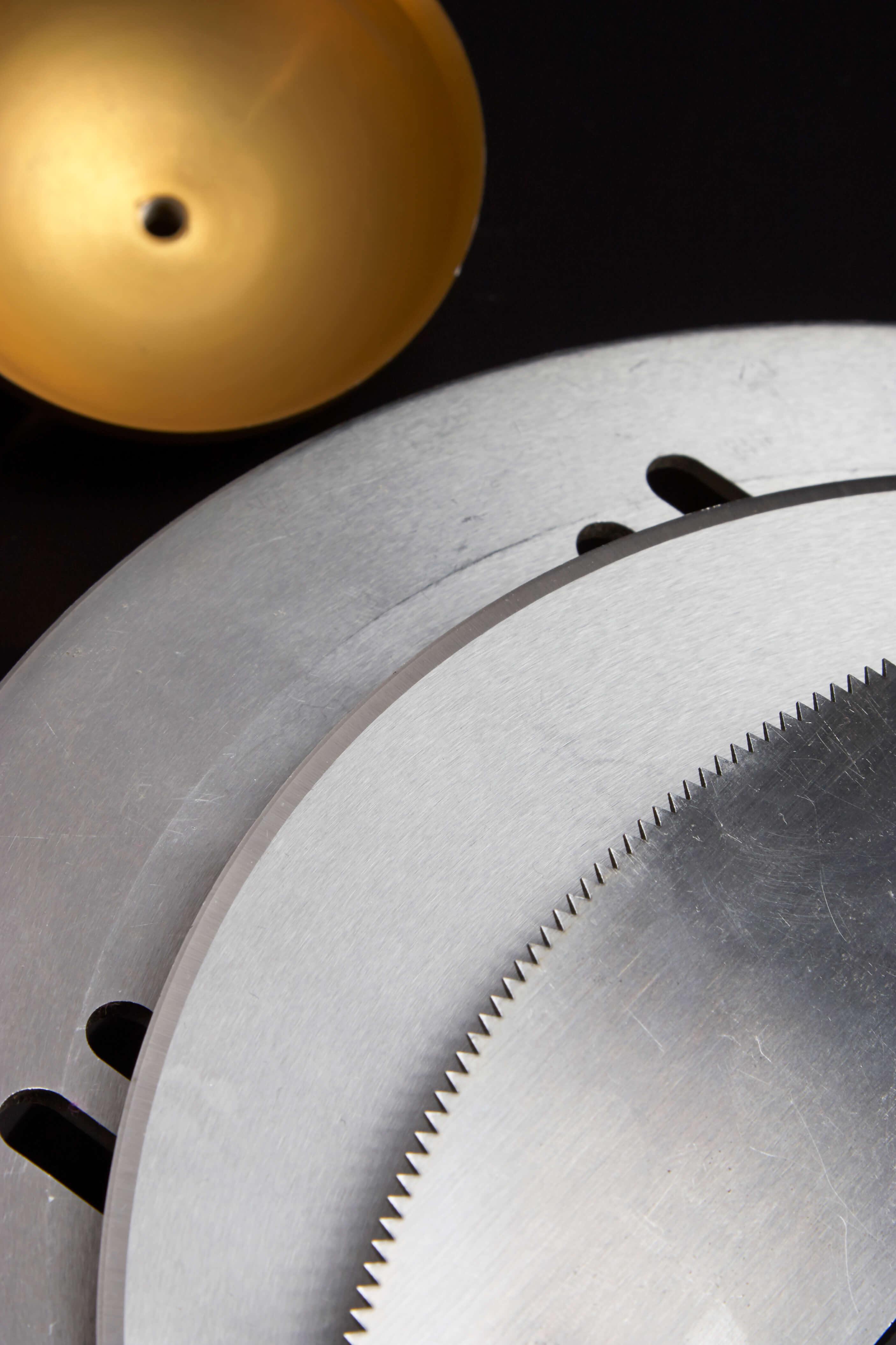 Close-up of circular industrial knives with smooth and serrated edges, manufactured by Durham Duplex for precision cutting applications.