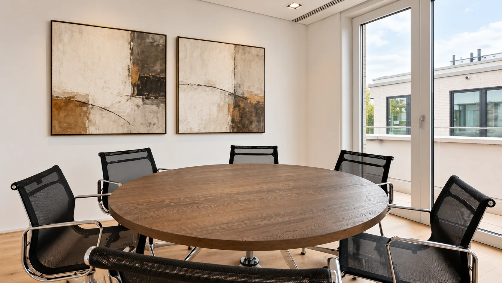 Besprechungsraum mit rundem Tisch und abstrakter Kunst