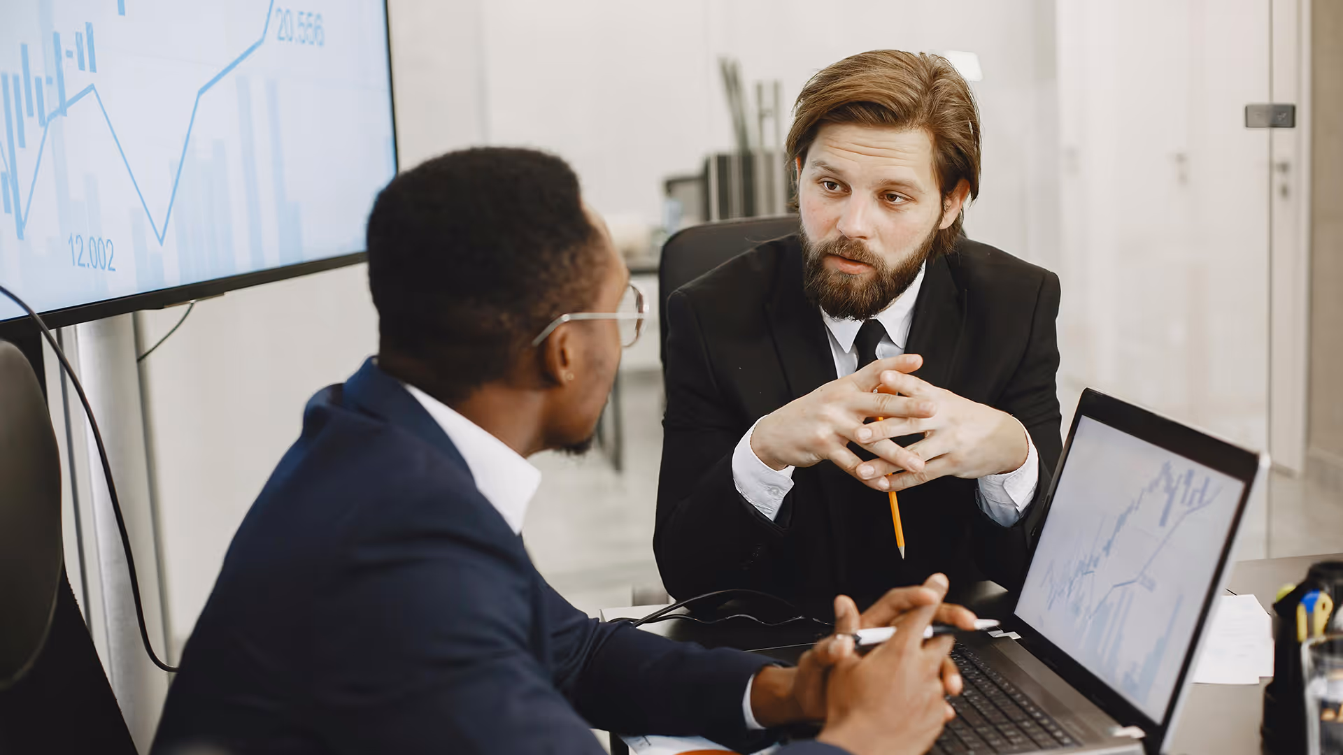 Two businessmen discussing travel merchant account options