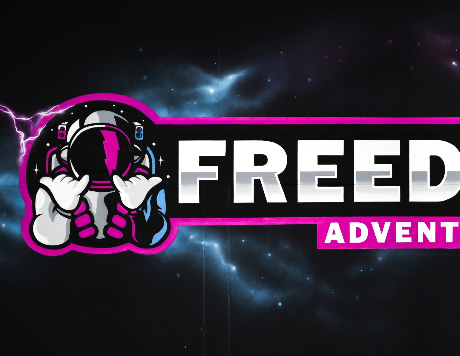 Illustration of an astronaut with a lightning bolt visor and pink and blue suit, showing the shaka hand sign beside bold white letters reading 'FREED' on a dark space background.