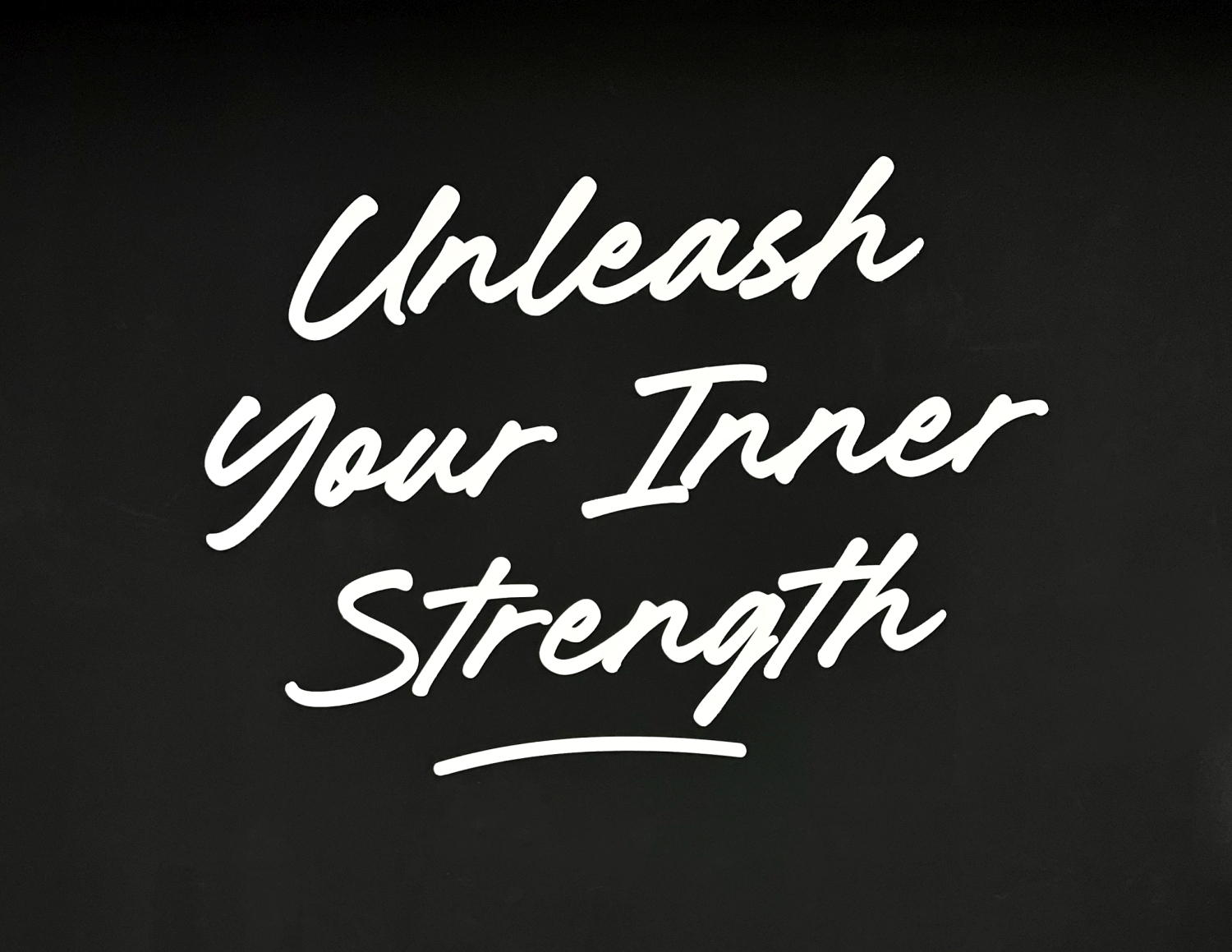 White handwritten text on black background saying 'Unleash Your Inner Strength' with 'Strength' underlined.