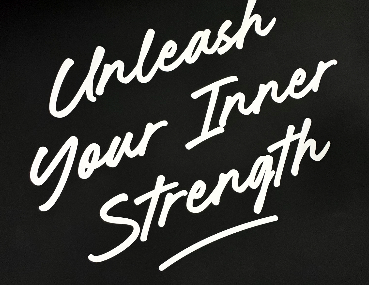 Text reading 'Unleash Your Inner Strength' in white script on a black background.