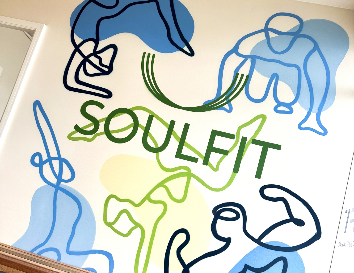 Wall mural with abstract continuous line drawings of people exercising around the word SOULFIT.