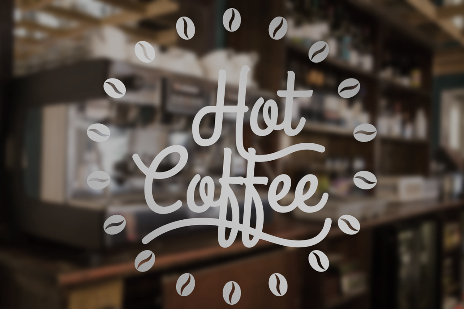 Glass window decal with 'Hot Coffee' text surrounded by coffee bean icons, showing a blurred coffee shop interior.
