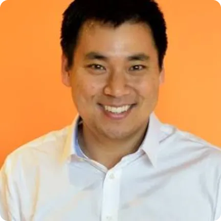 A man in a white shirt smiling at the camera.