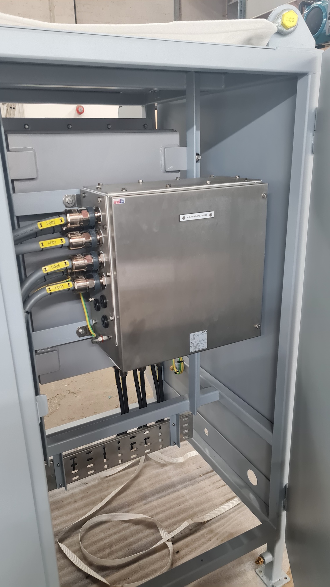 Stainless-steel control enclosure with labelled cable terminations.