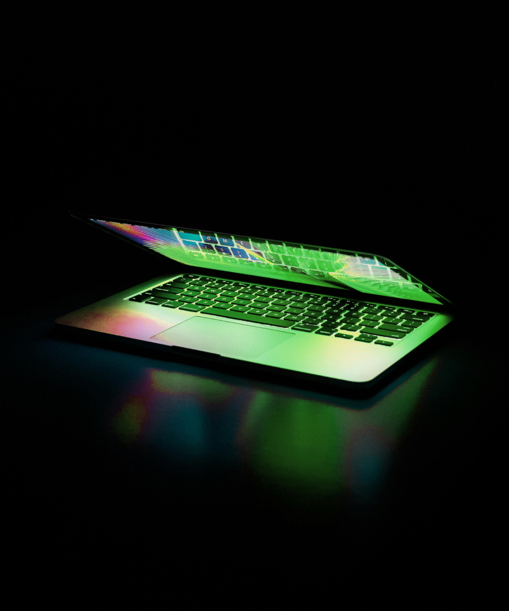 Open laptop glowing in dark light symbolising online mentoring and ongoing expert support at Turn Heads Global.