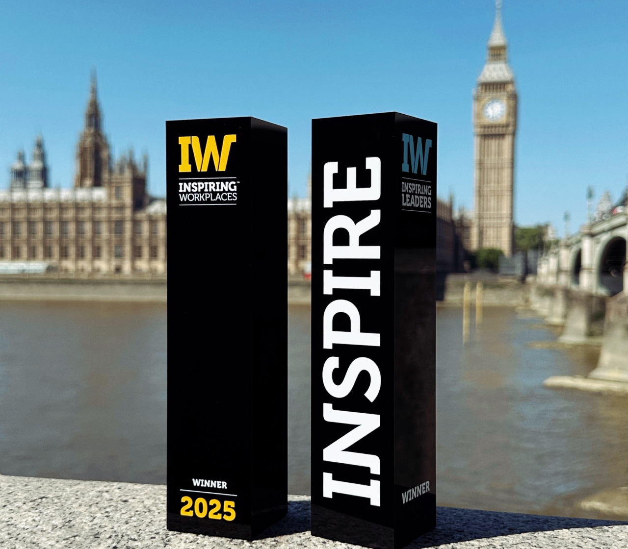 Inspiring Workplaces and Inspiring Leaders award pillars near Big Ben representing recognition for culture and leadership strategy by Turn Heads Global.