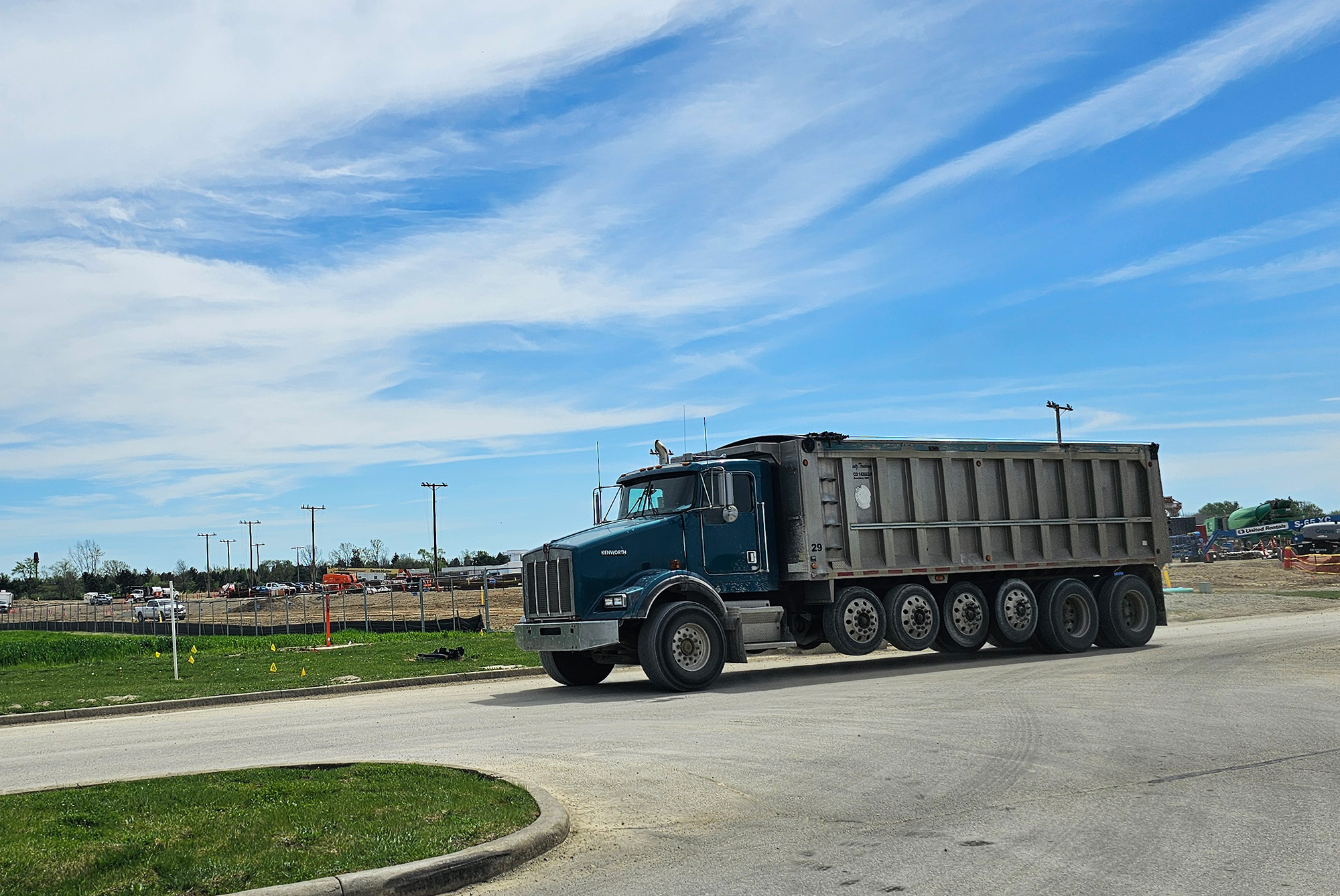 A dump truck at a job site on the road. 
