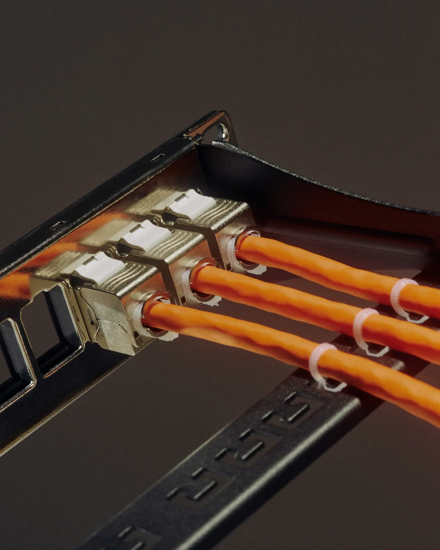 A close up of a black box with orange wires coming out of it.