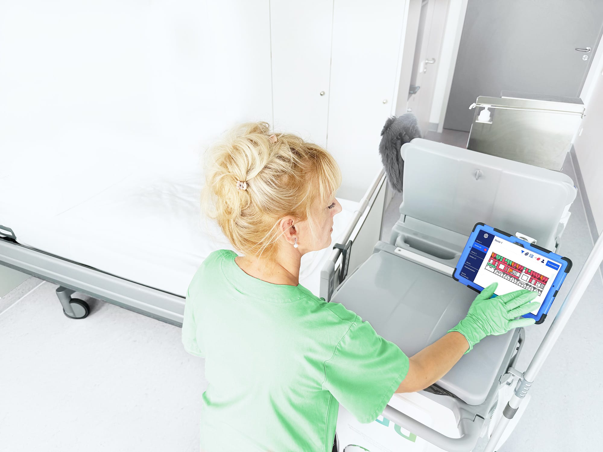 Reinigungskraft nutzt die soobr App auf Tablet für digitale Reinigungsplanung im Patientenzimmer