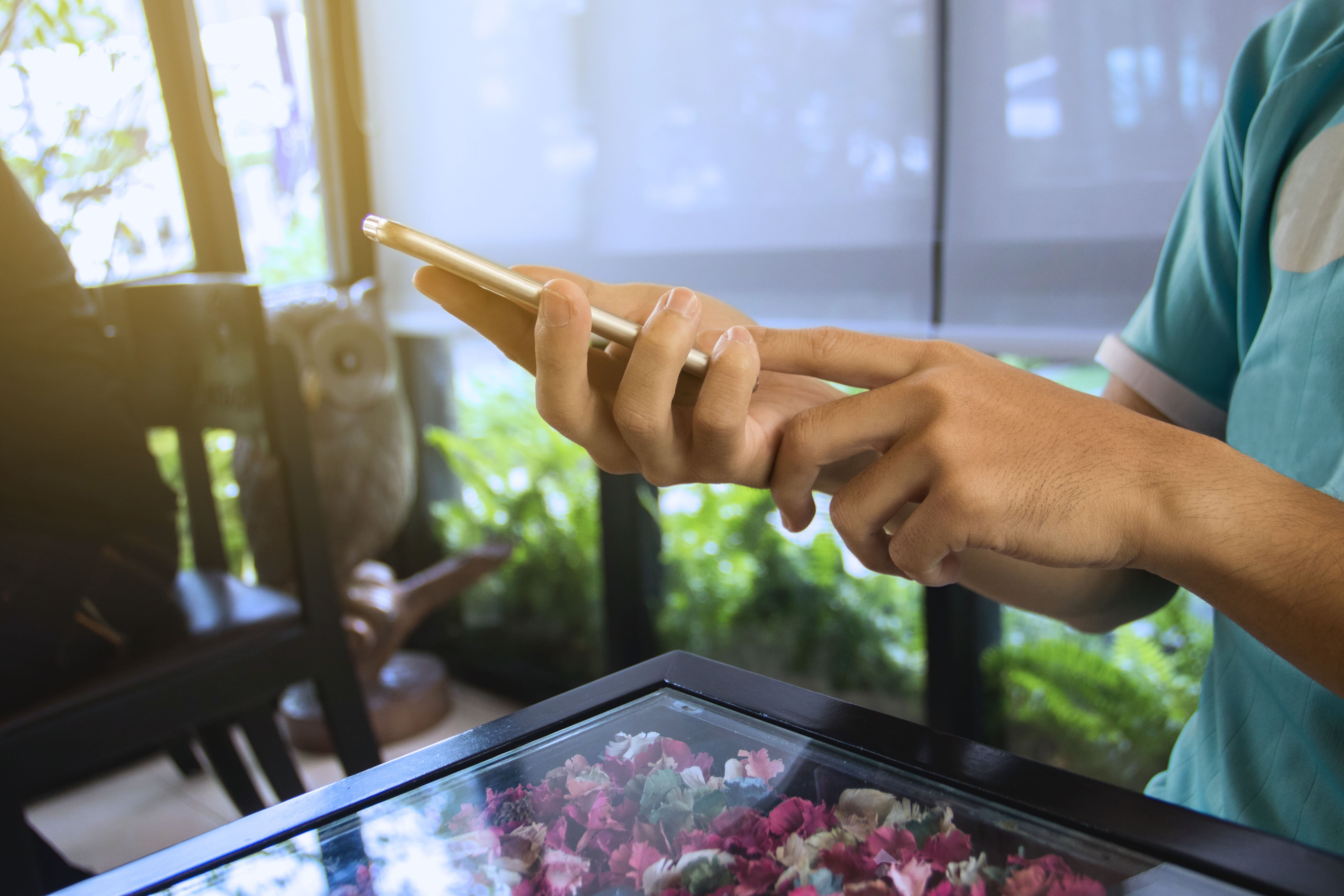 Eine Frau tippt in einer Pflegeeinrichtung auf ihrem Smartphone