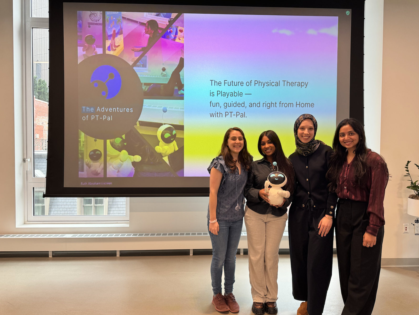 Sammy and her teammates, 4 women, presenting at the NYC Design Factory Gala. They are holding their robot prototype.