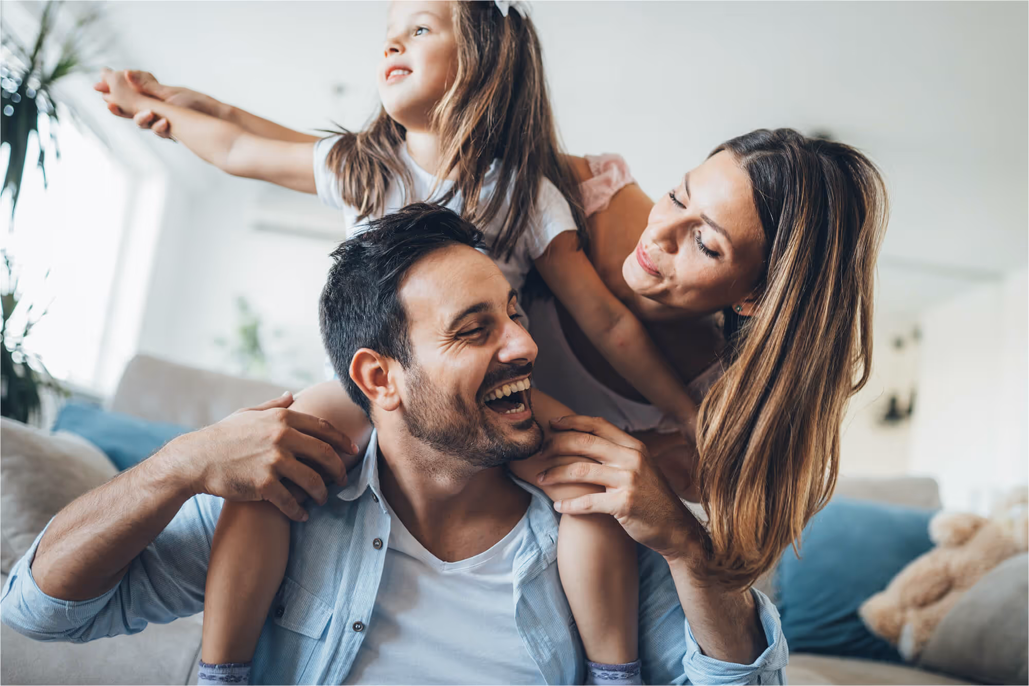 A man holding a little girl on his shoulders.