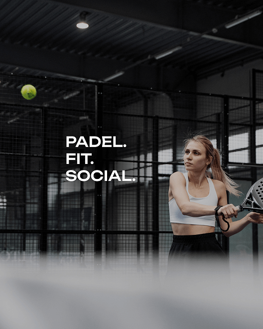 Woman playing padel with a black padel racket at an indoor padel facility