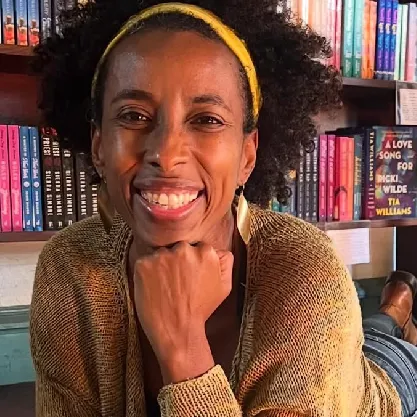 Yoga teacher smiling at camara.