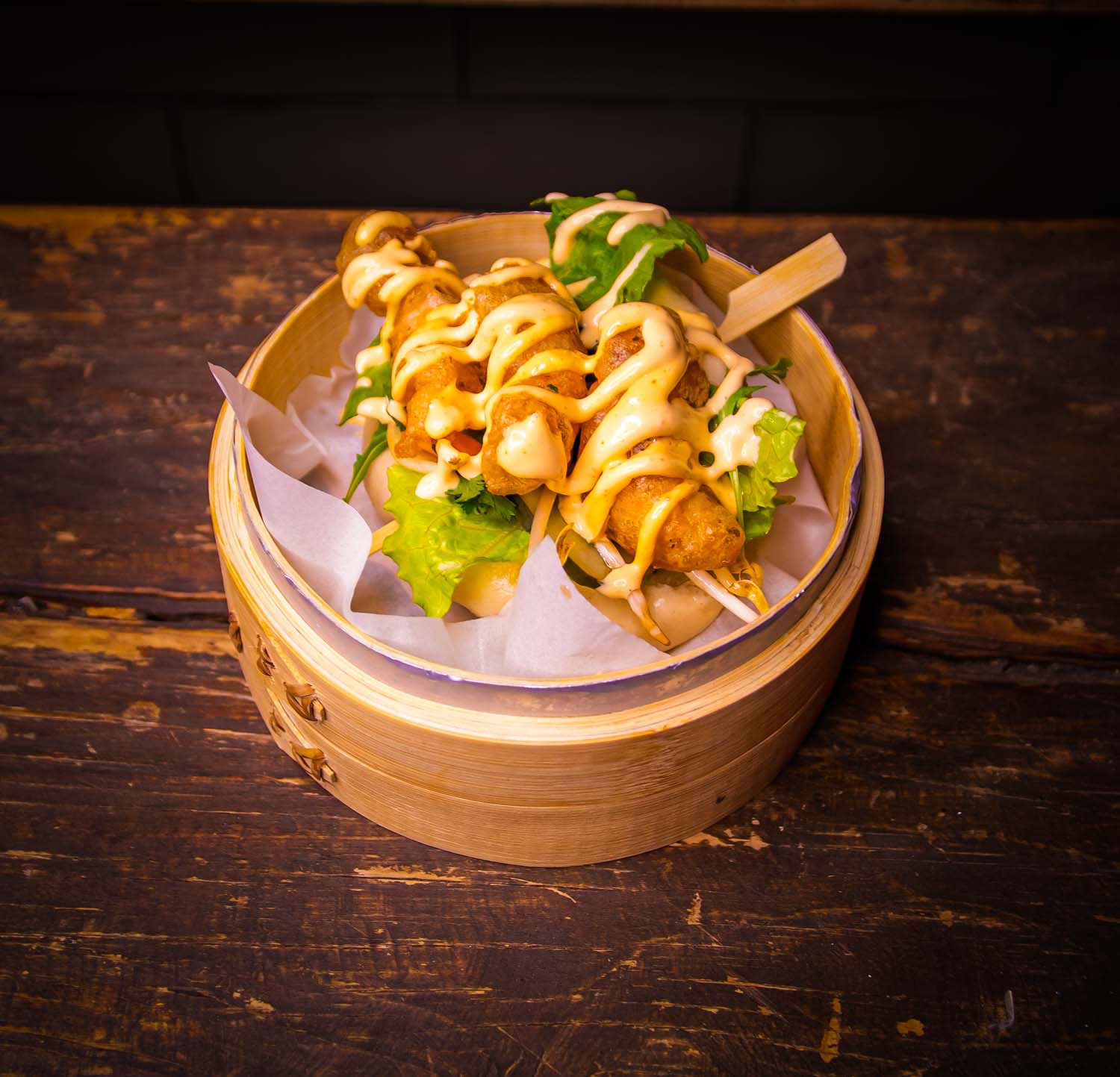 Delicious shrimp tempura bao sandwich with fresh vegetables and Koku mayonnaise on a soft steamed bun