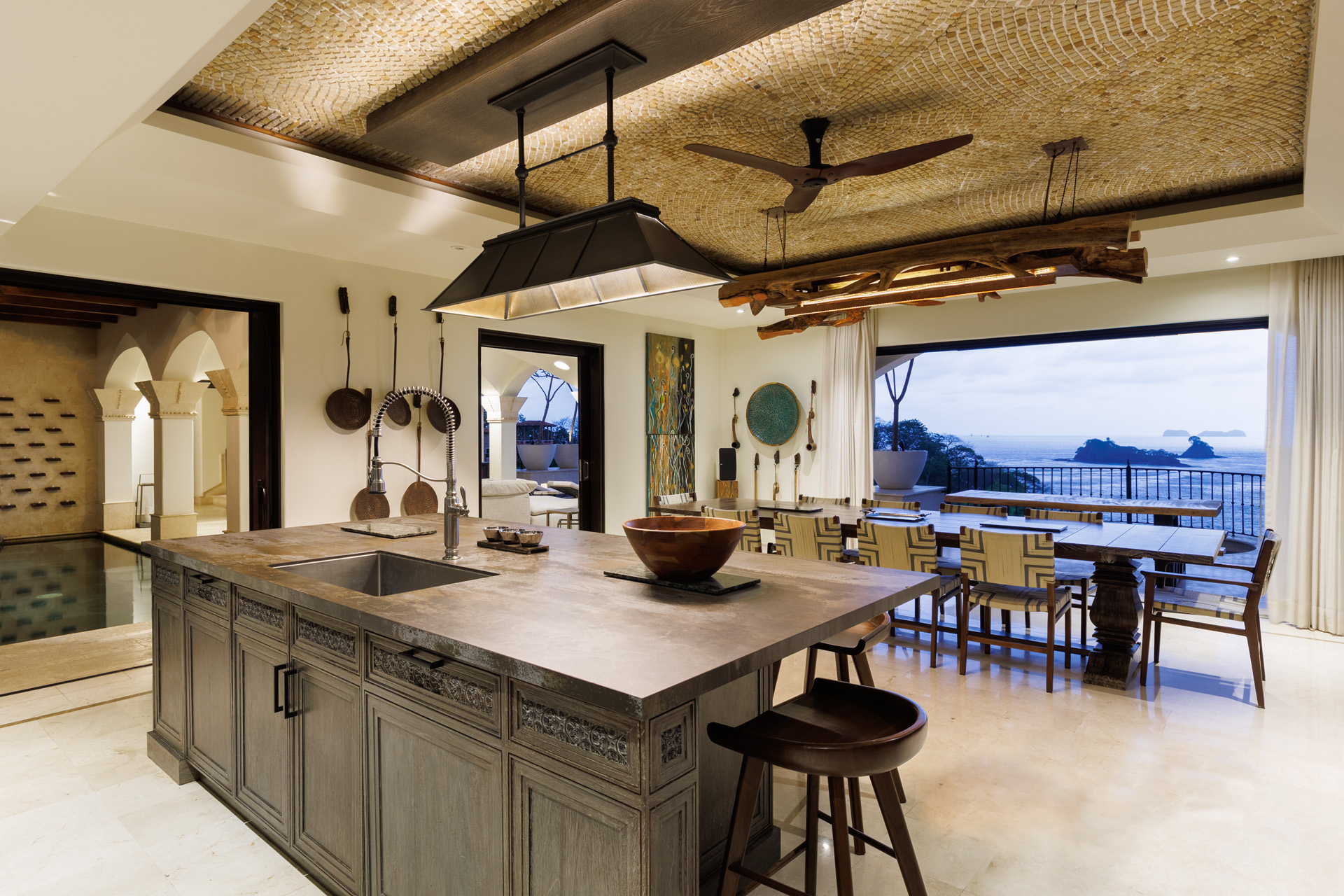 Open chef's kitchen and dining area of a luxury villa with ocean views