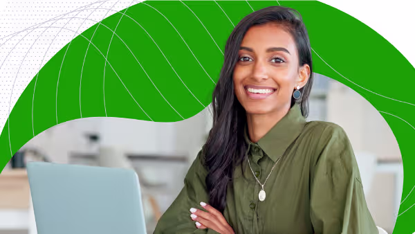 Woman smiling at a laptop in an office setting