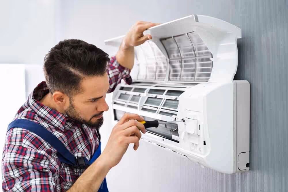 A worker repairing a wall unit.