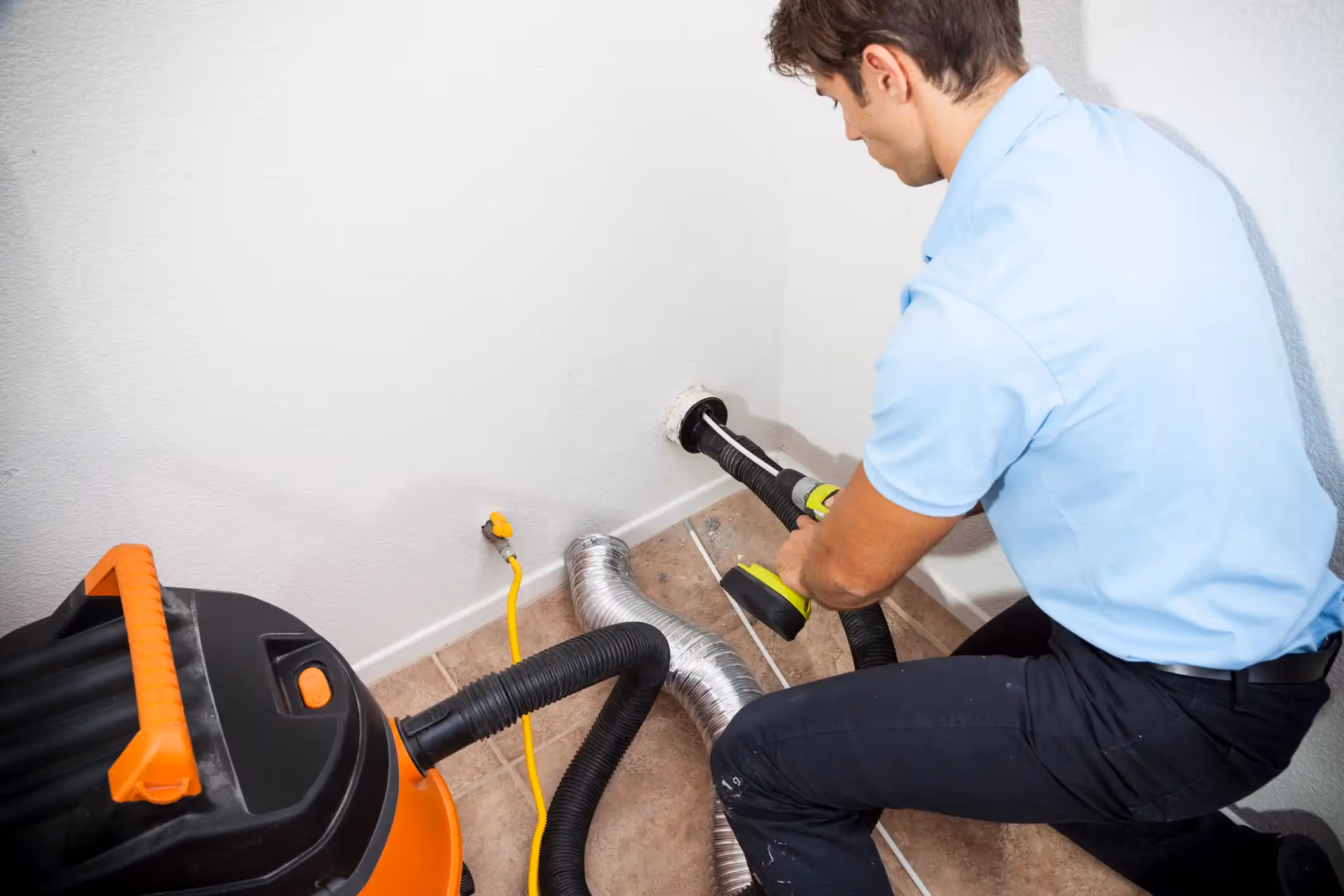 A worker cleaning an air duct.