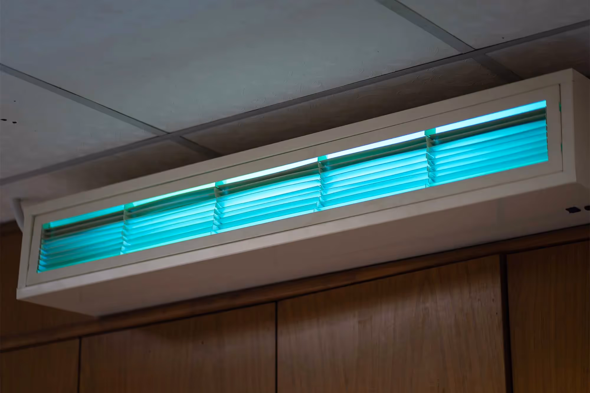A glowing UV germicidal lamp on a ceiling.