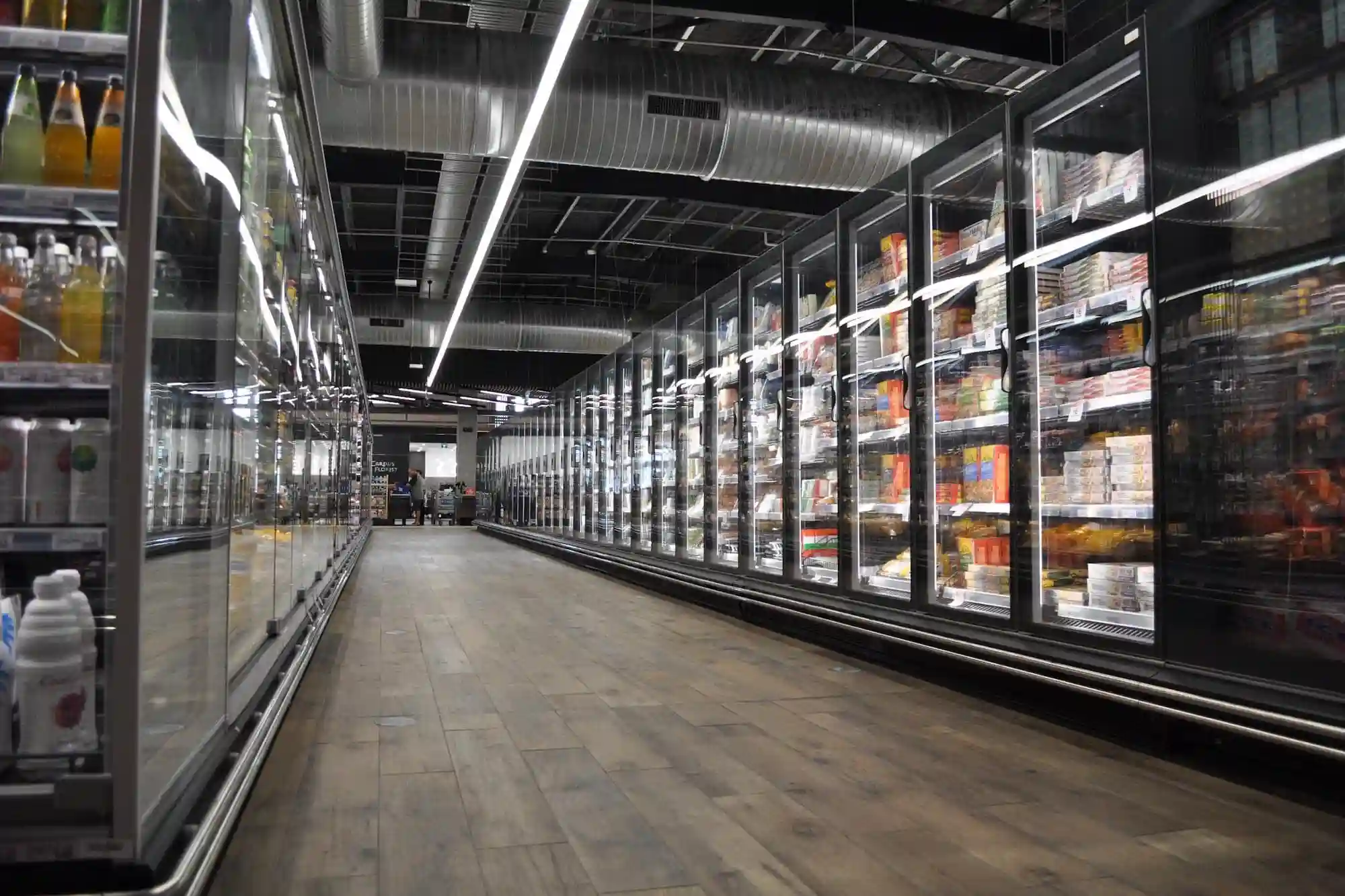 A grocery store aisle with refrigerator units.