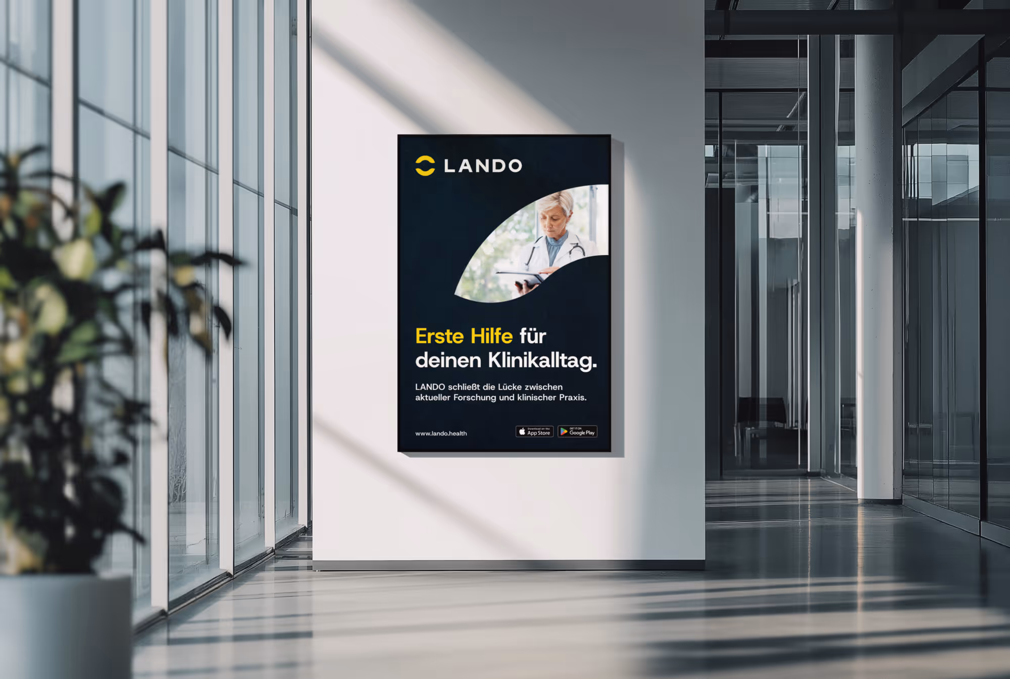 Werbeplakat in modernem Gebäude zeigt LANDO App zur Unterstützung des Klinikalltags mit Bild einer Ärztin.