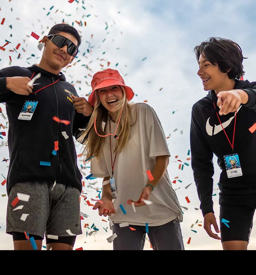 students with confetti smiling for camera