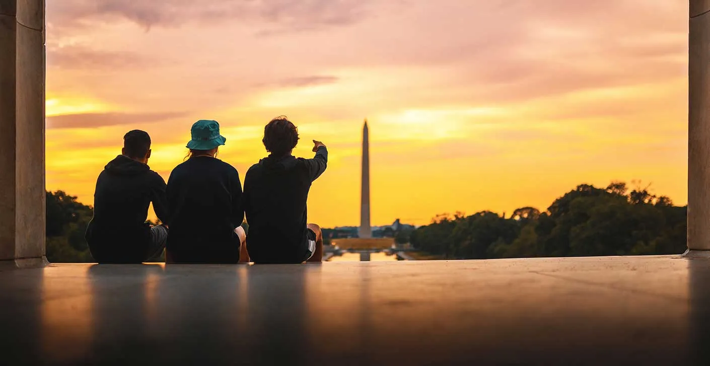 students sitting on lincoln memorial steps at sunset