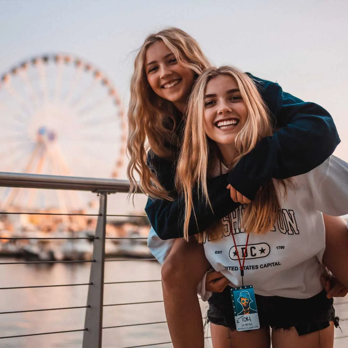 happy girls with ferris wheel in background