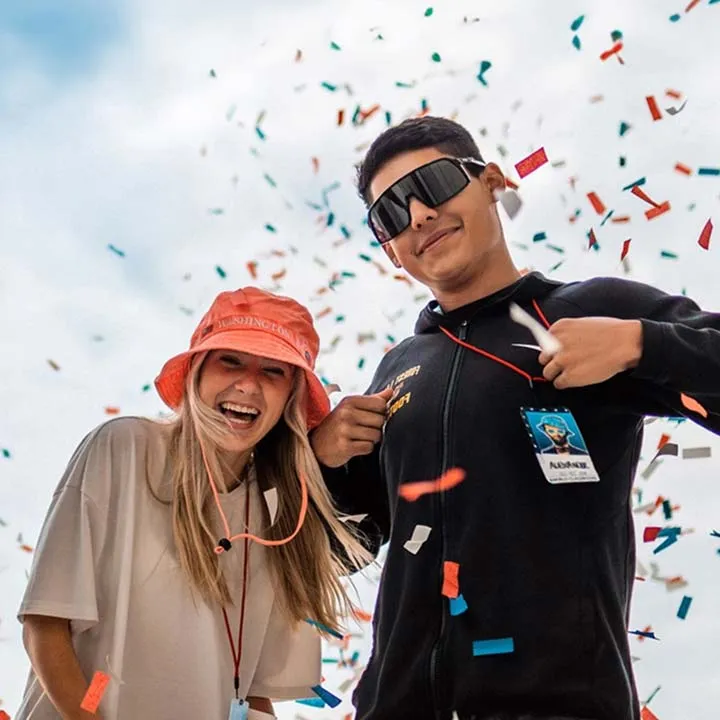 students with confetti smiling for camera