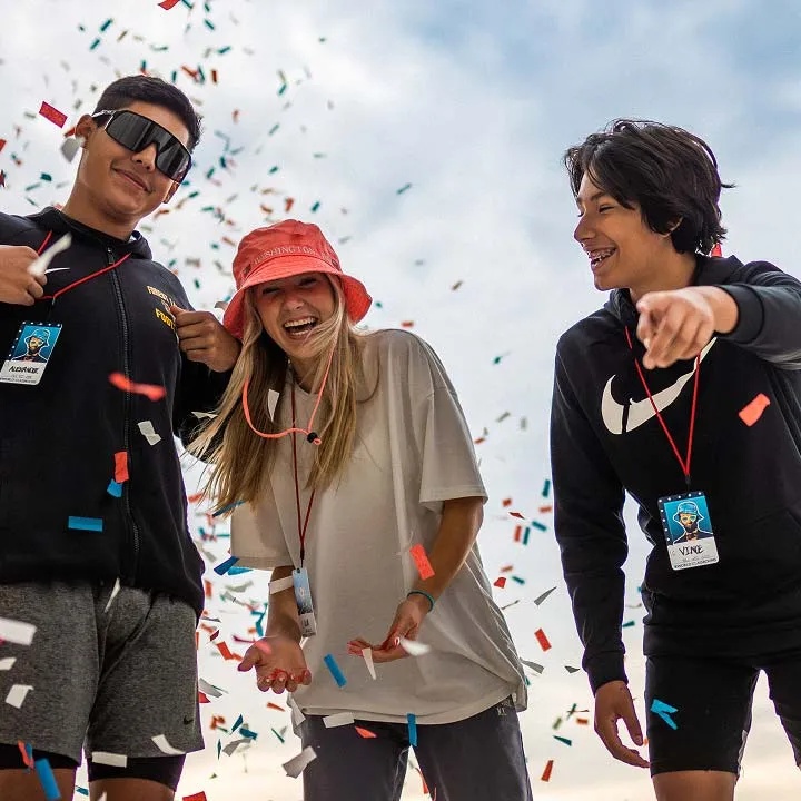 students with confetti smiling for camera