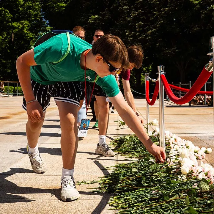 student setting rose on memorial