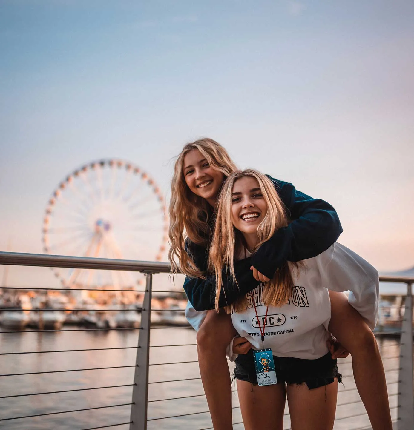 happy girls with ferris wheel in background