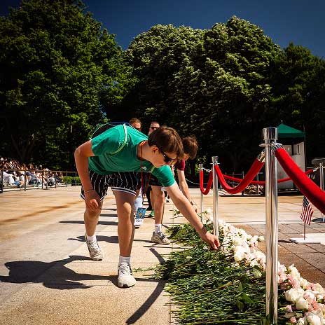 student setting rose on memorial