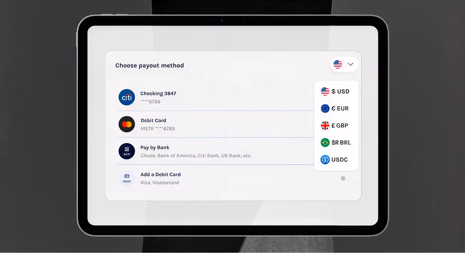 Tablet screen showing payout methods: checking, debit card, bank pay, add card, with currency options dropdown.