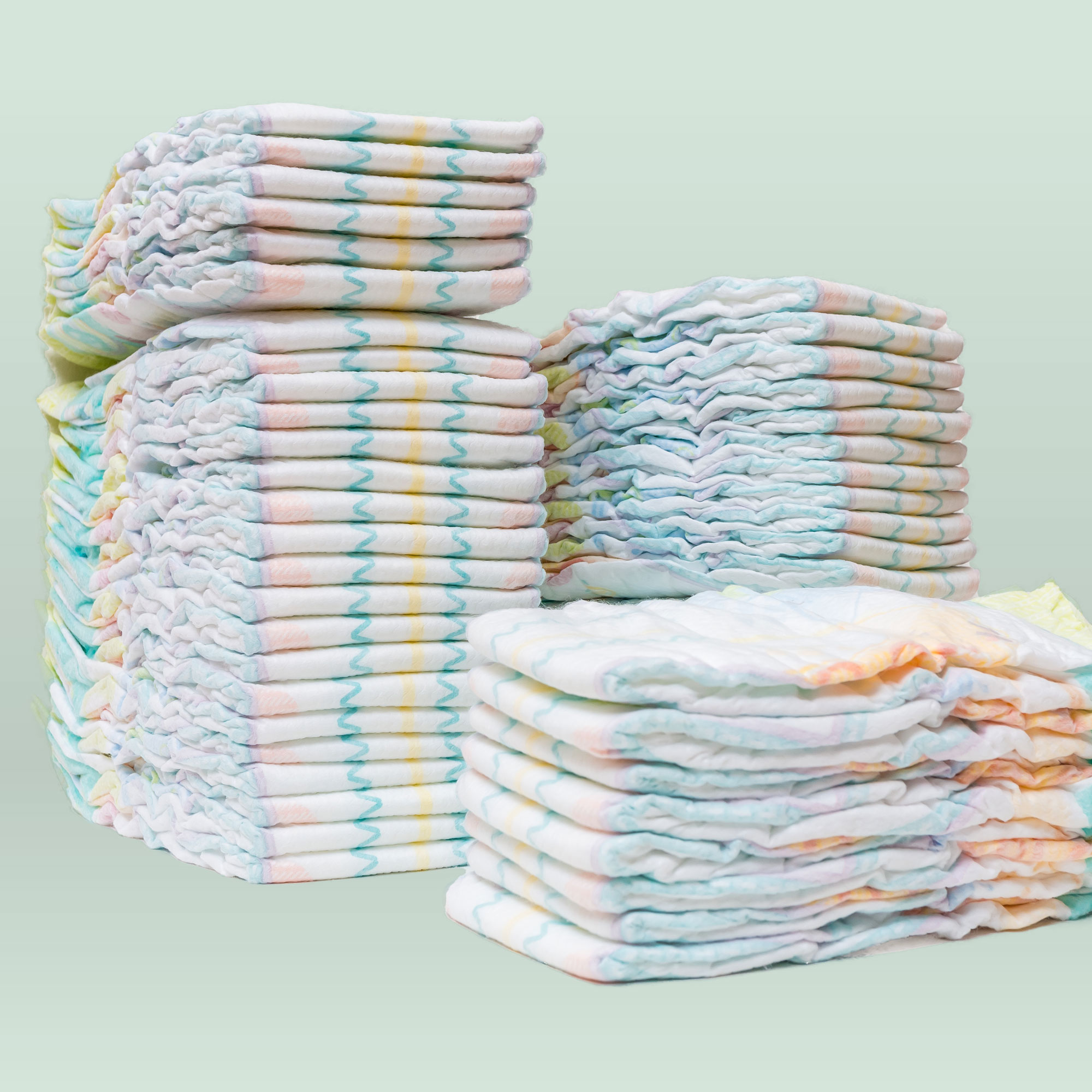 Stacks of diapers on light blue background