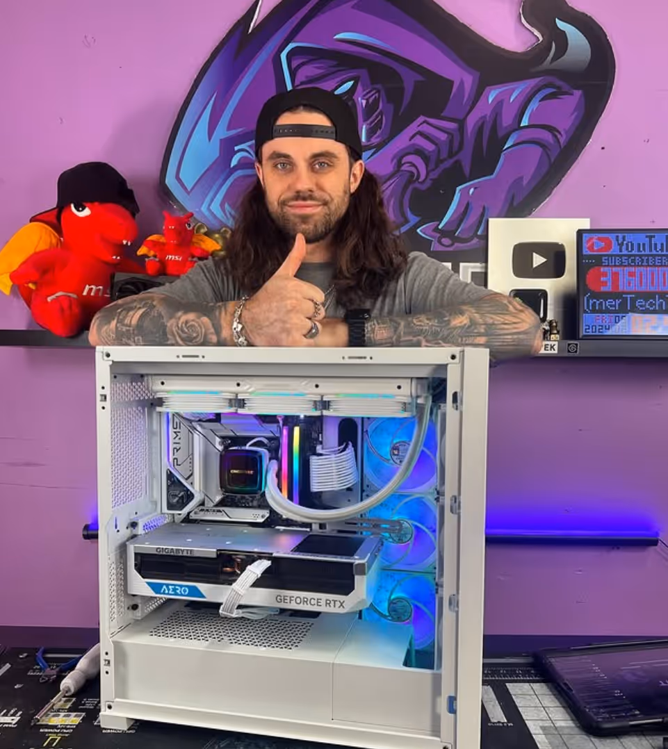 Mack Falcon with his logo of a falcon in the background. Mack giving the thumbs up by his computer.