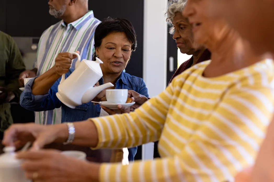 senior woman serving coffee at function