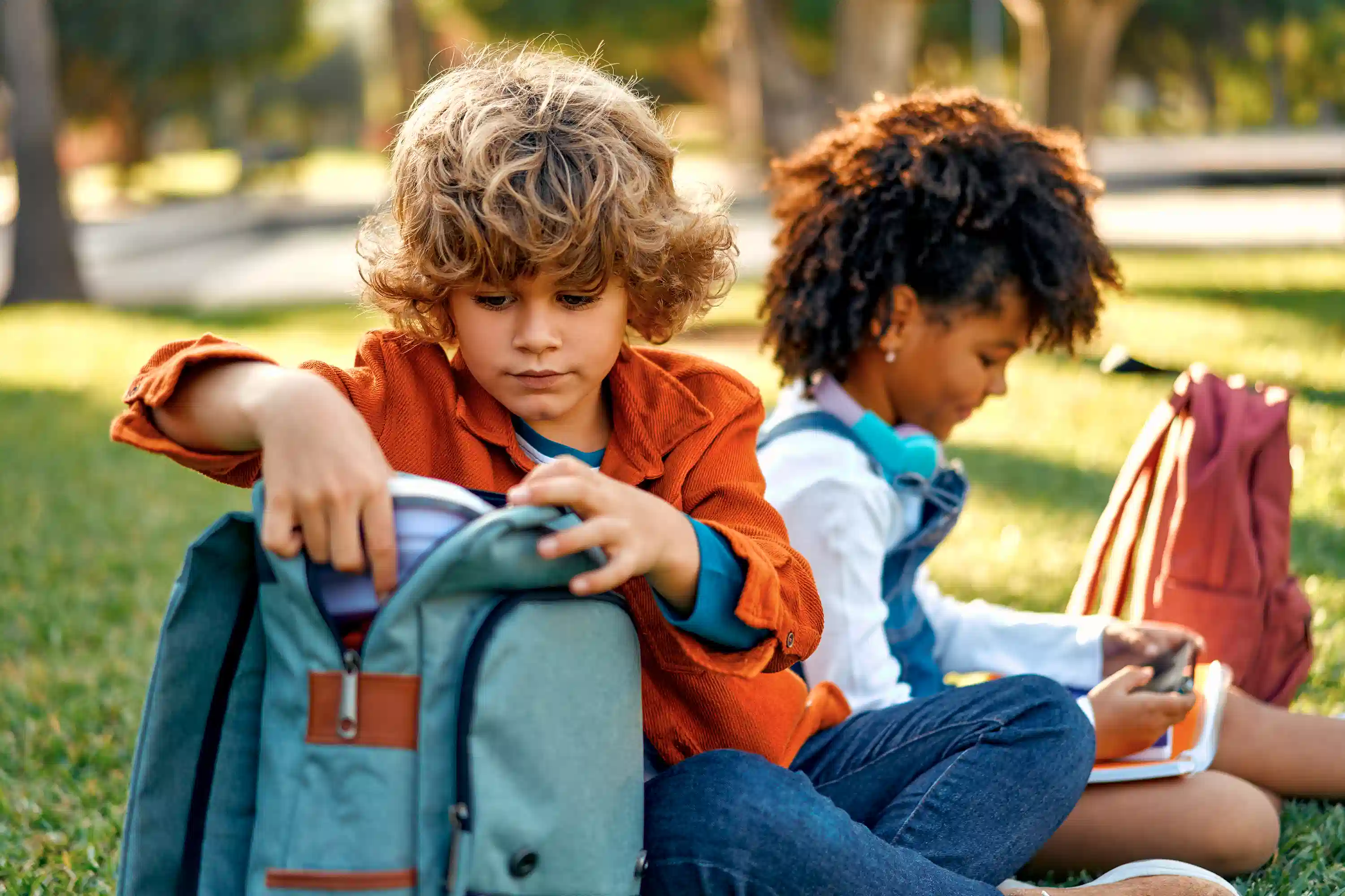 school children sitting on grass