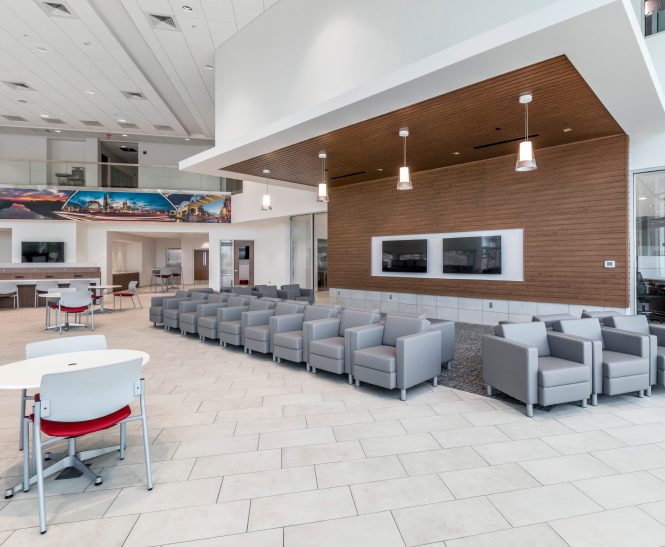 An  interior view of the Toyota waiting room with gray couches and tables