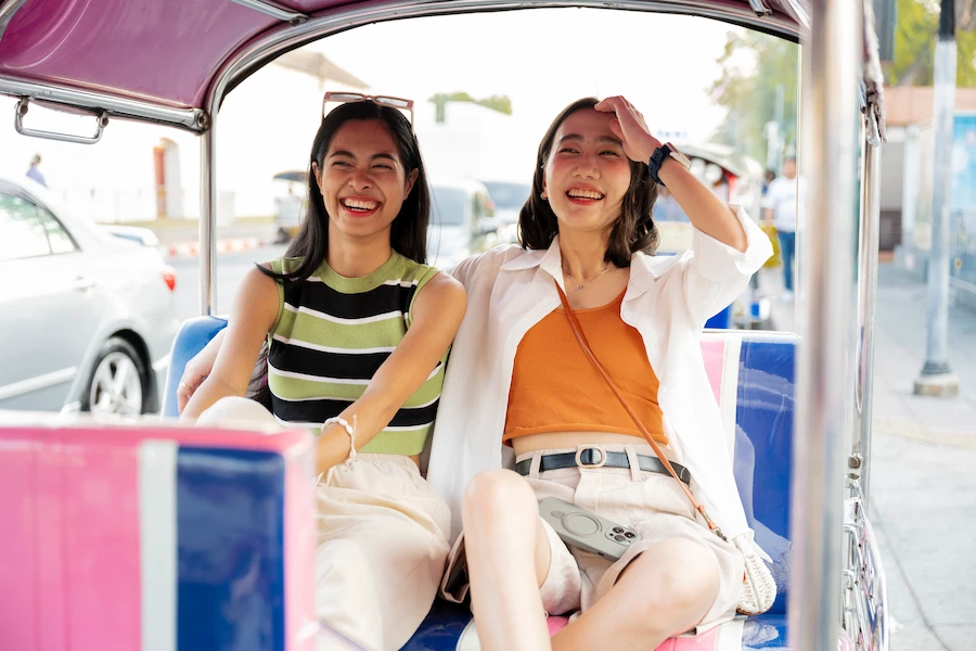 two happy women in back of trishaw